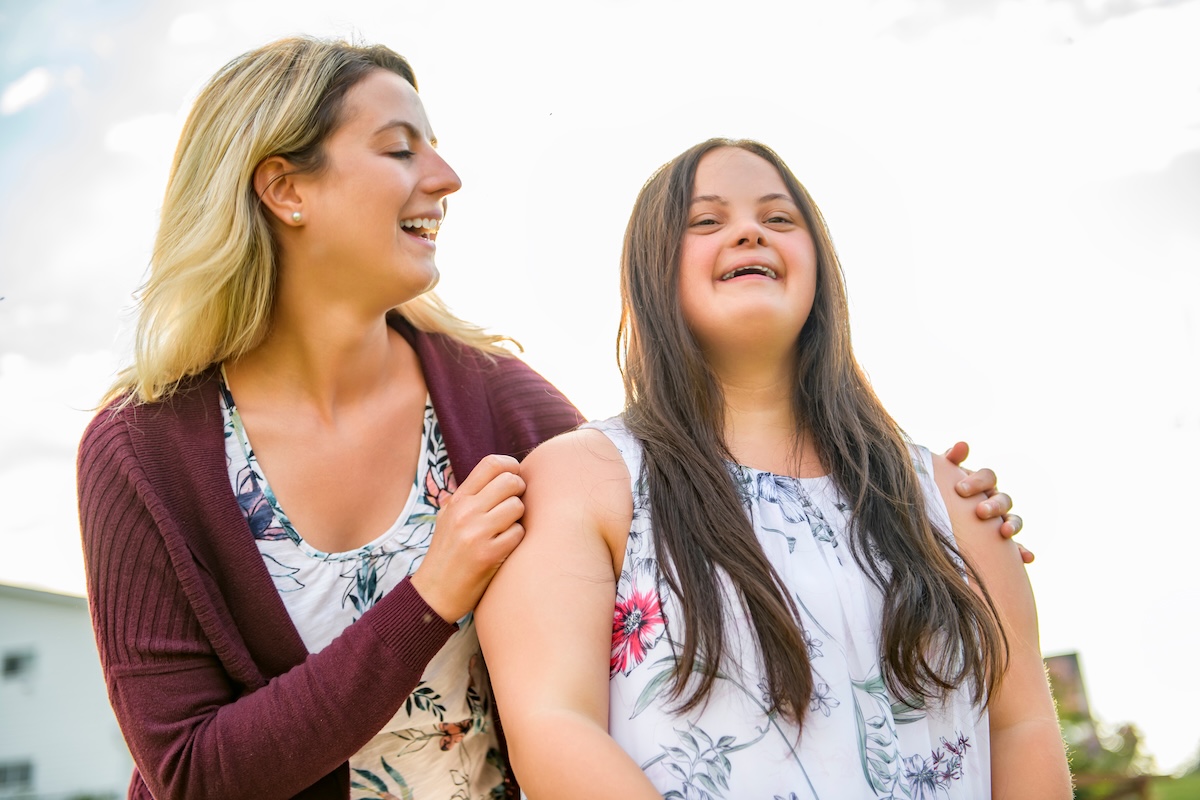Woman with Down syndrome laughing with her sister