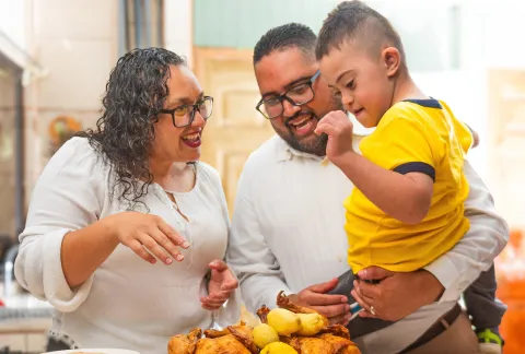 Boy with Down syndrome in a kitchen with his parents