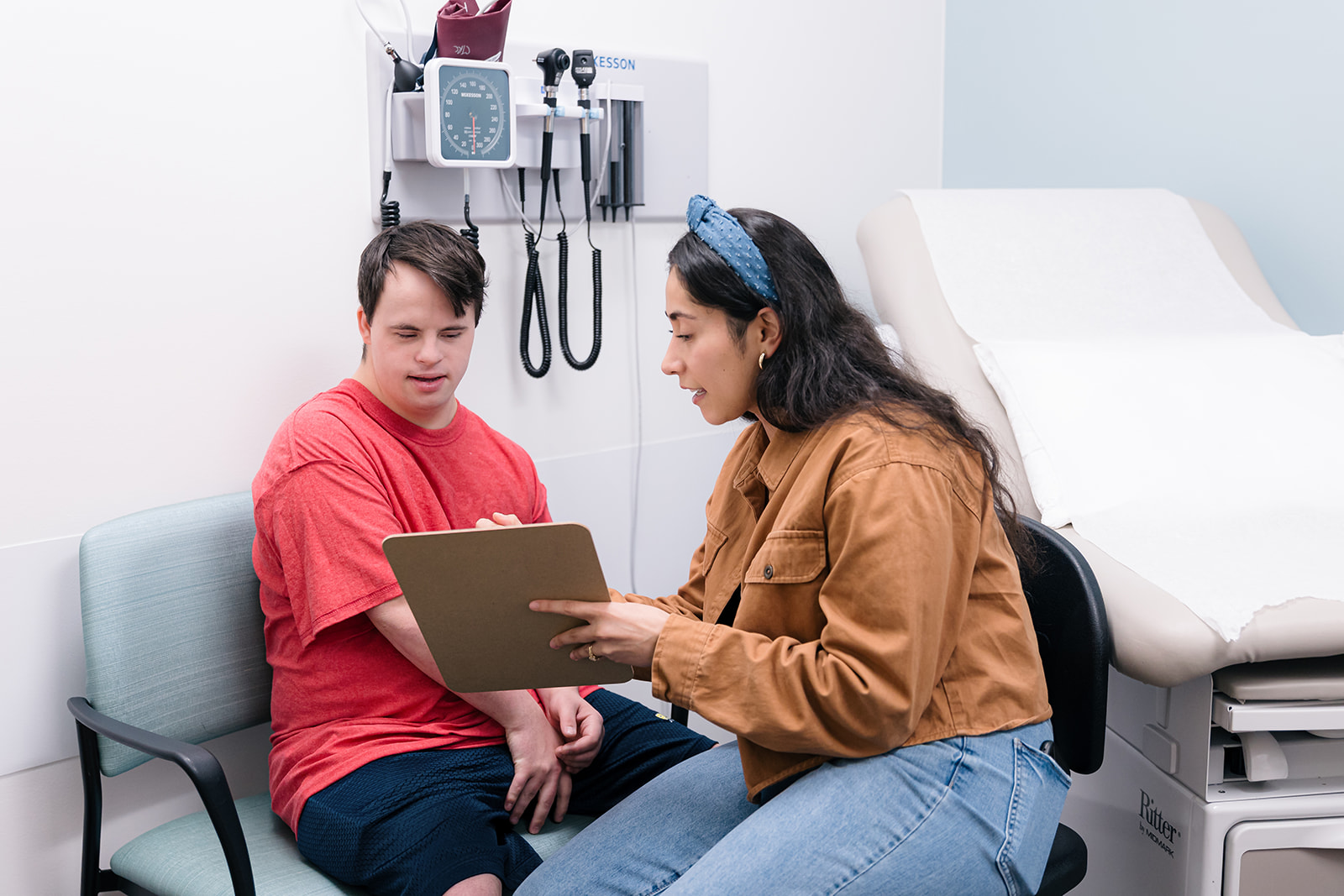 Young man with Down syndrome speaking with a medical professional at an appointment