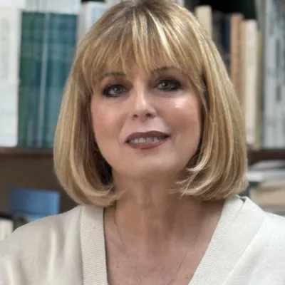 a photo of Sharon Krinsky smling in a library 