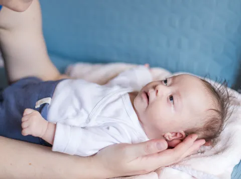 Adult holding a very young infant with Down syndrome