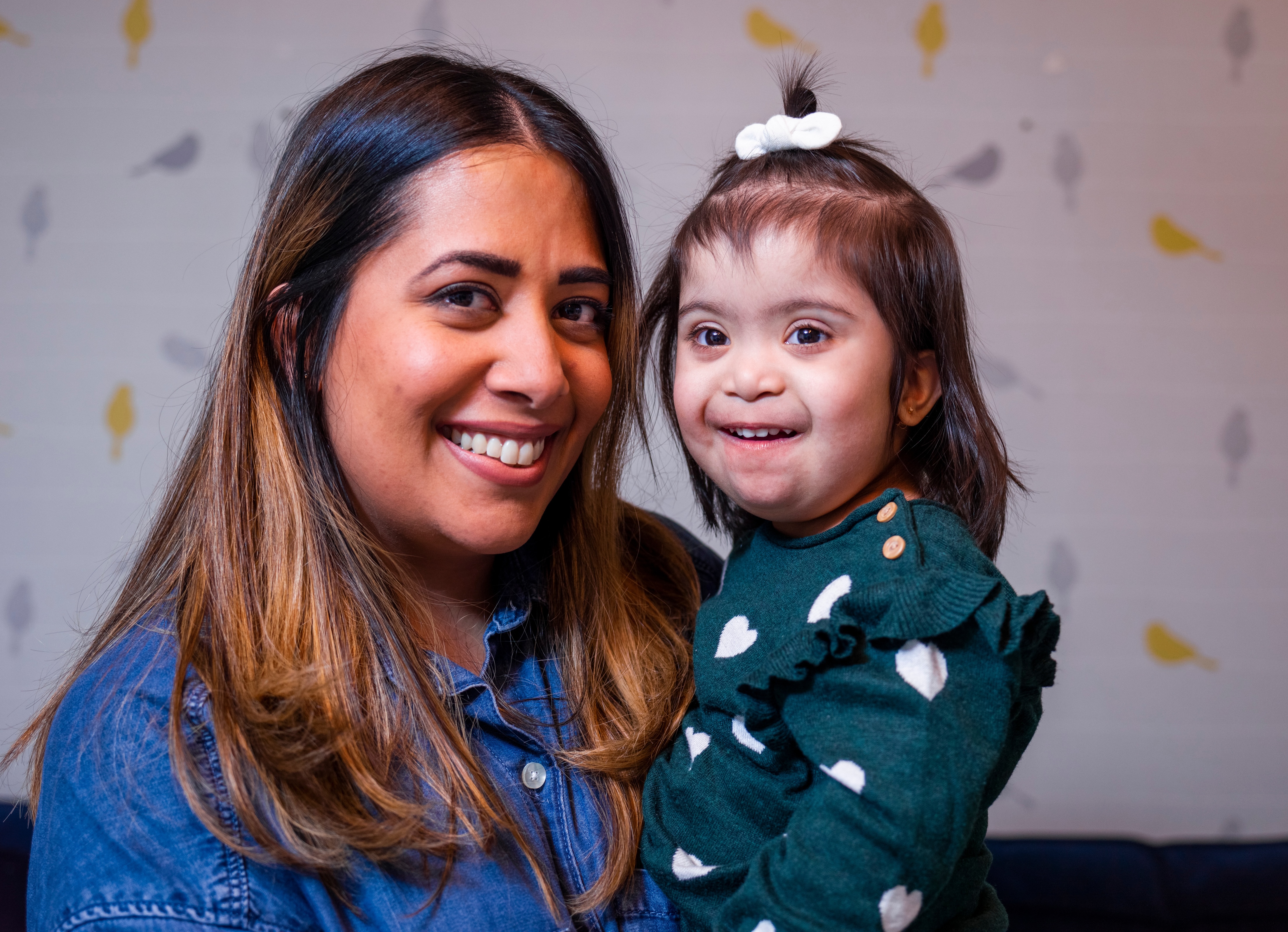 Mom smiling and holding her daughter with Down syndrome