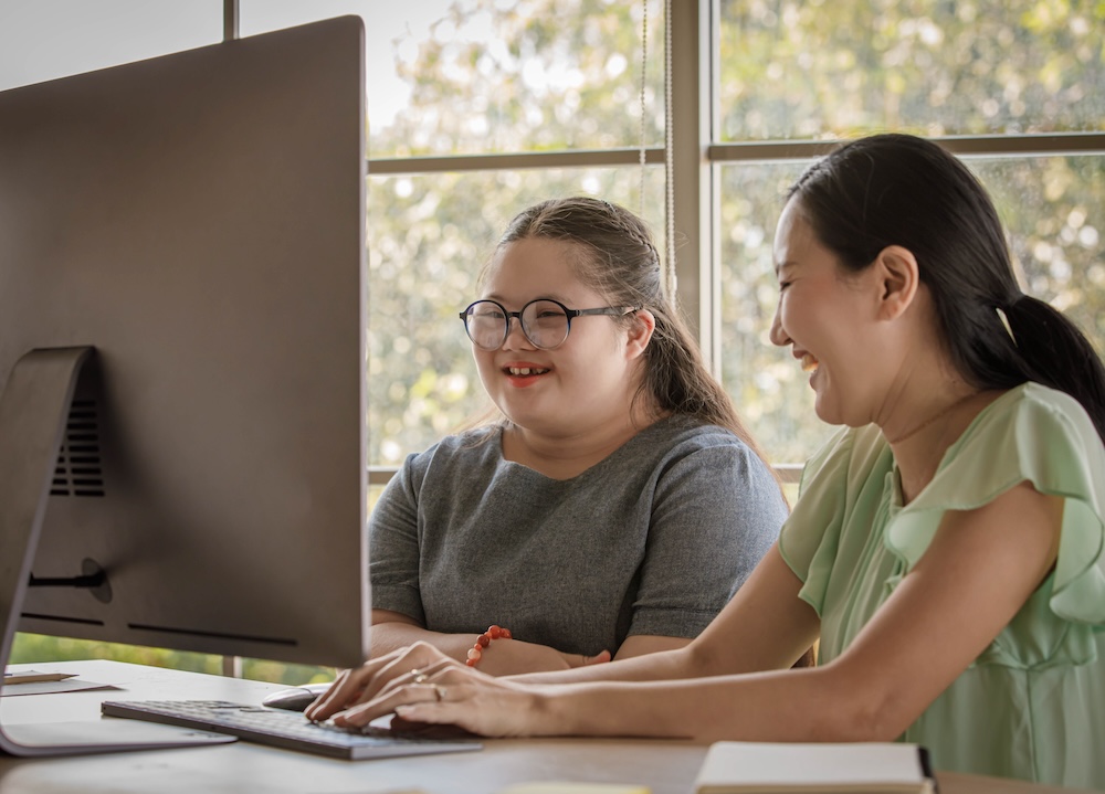 Mother and daughter with Down syndrome at a computer