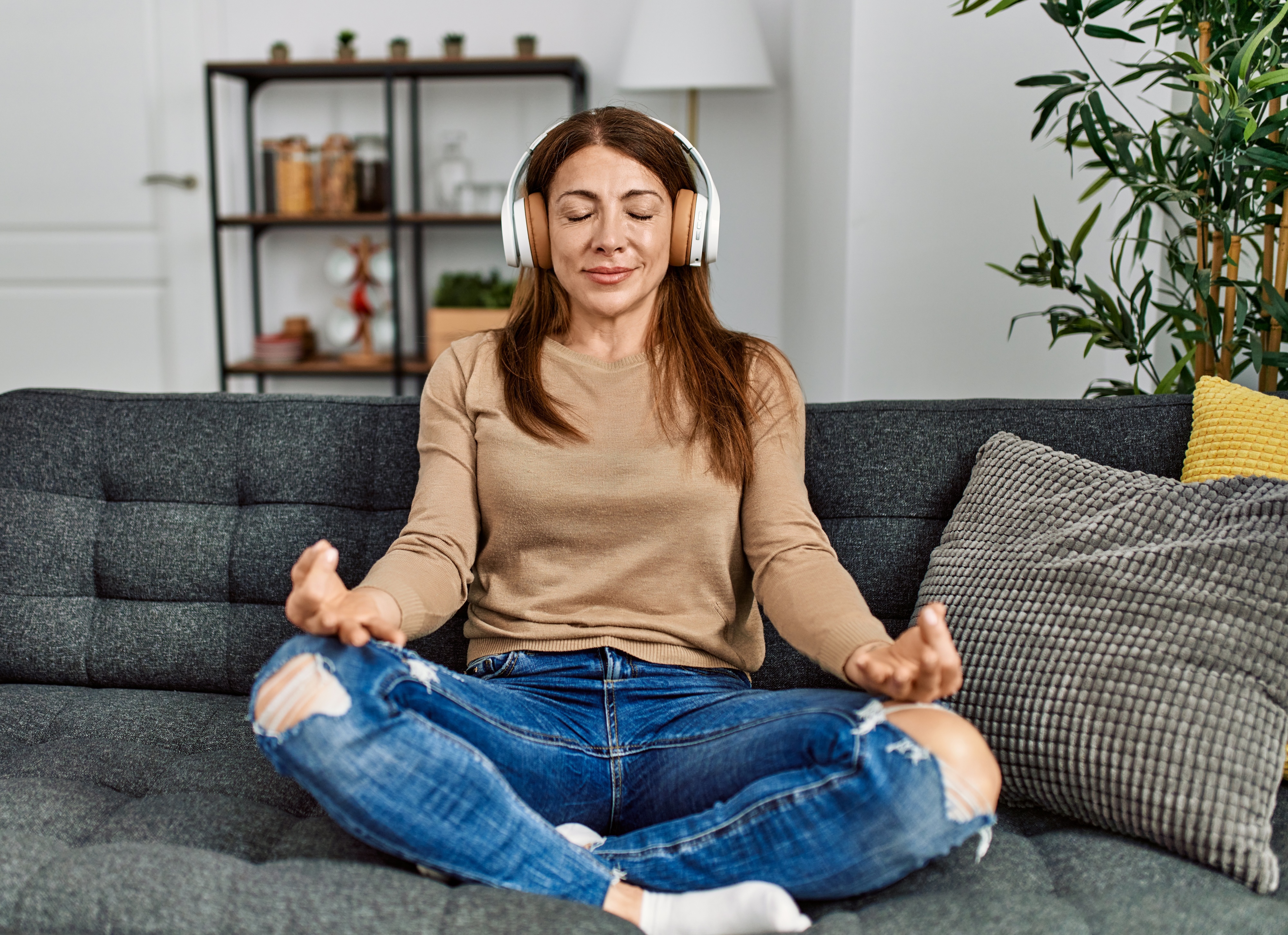Woman listening to a meditation session in her living room