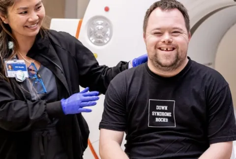 Researcher with person with Down syndrome smiling