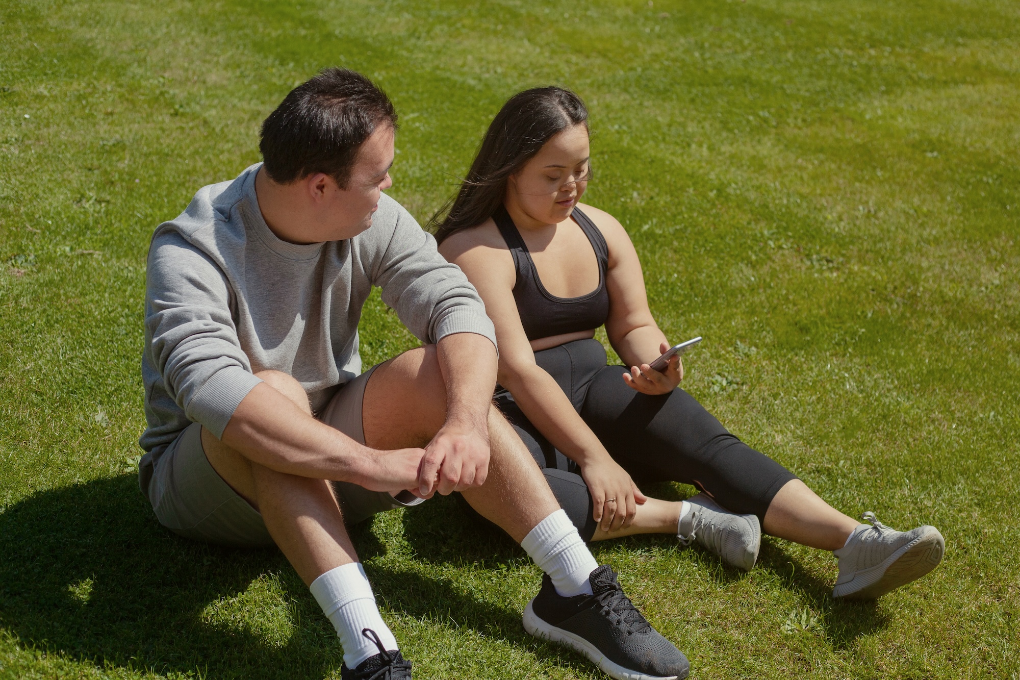 Young woman with Down syndrome looking at a phone with her friend