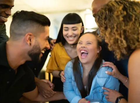 Woman with Down syndrome laughing with friends