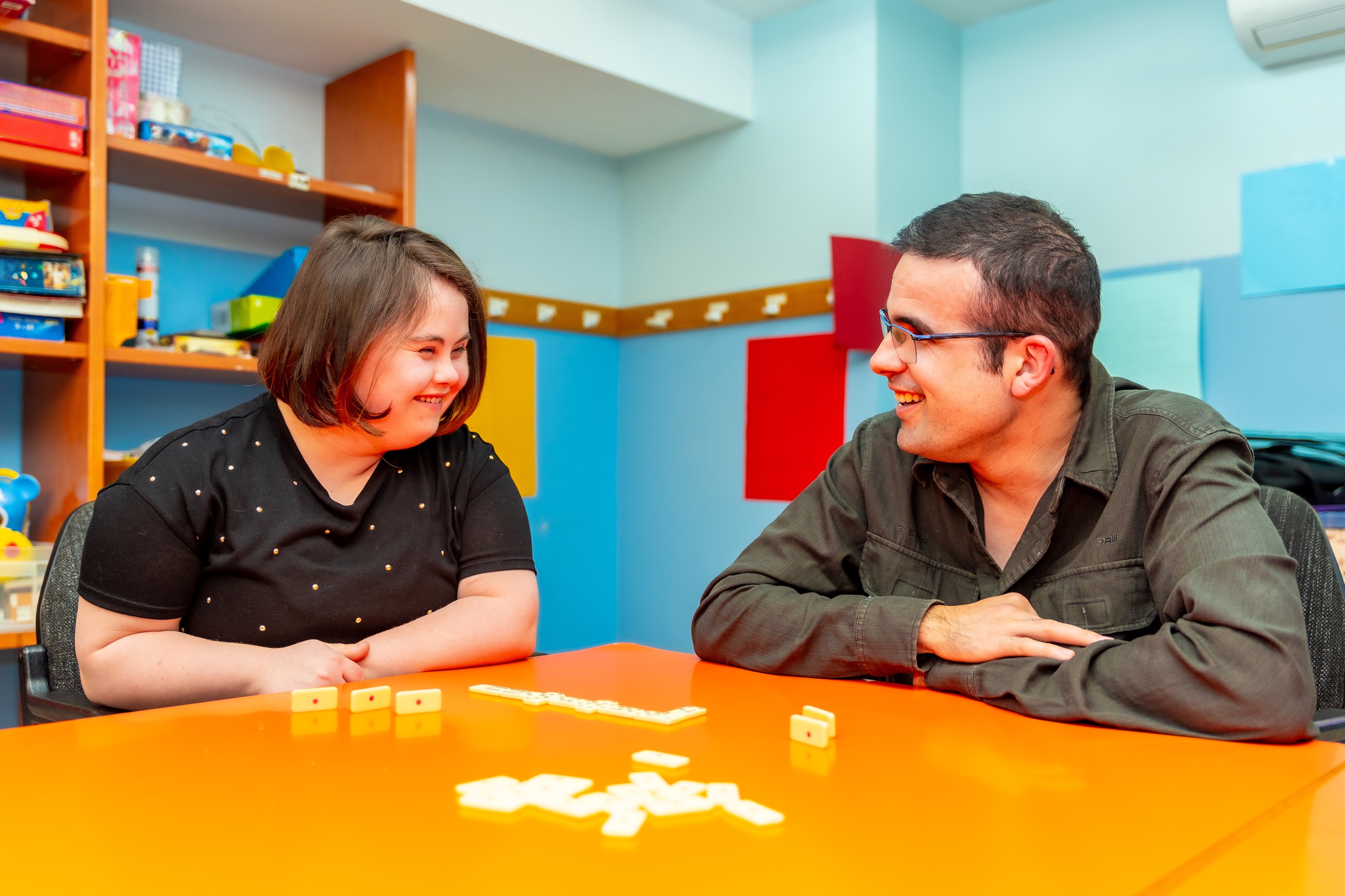 Woman with Down syndrome playing a game at a table with a man