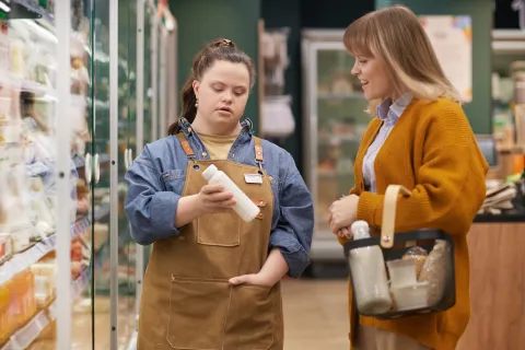 Mujer con síndrome de Down trabajando en una tienda de comestibles