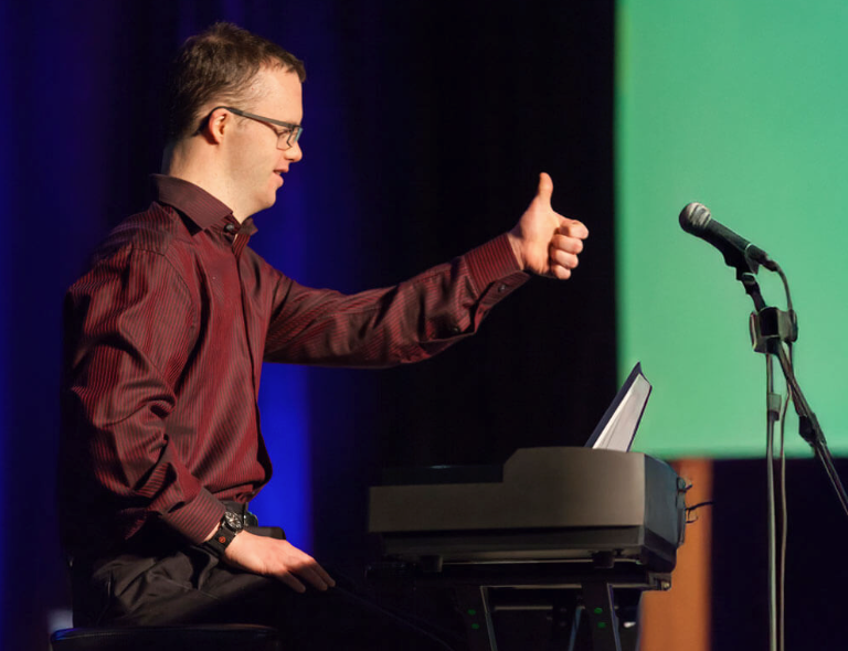 Man with Down syndrome speaking at the conference