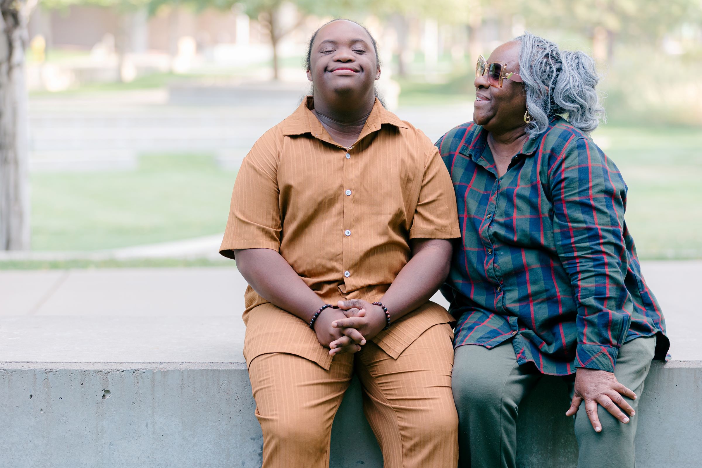 Man with Down syndrome and his mother sitting together and smiling